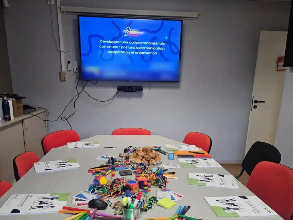 Salle de formation PCM intra-entreprise préparée avec manuels et matériel pédagogique